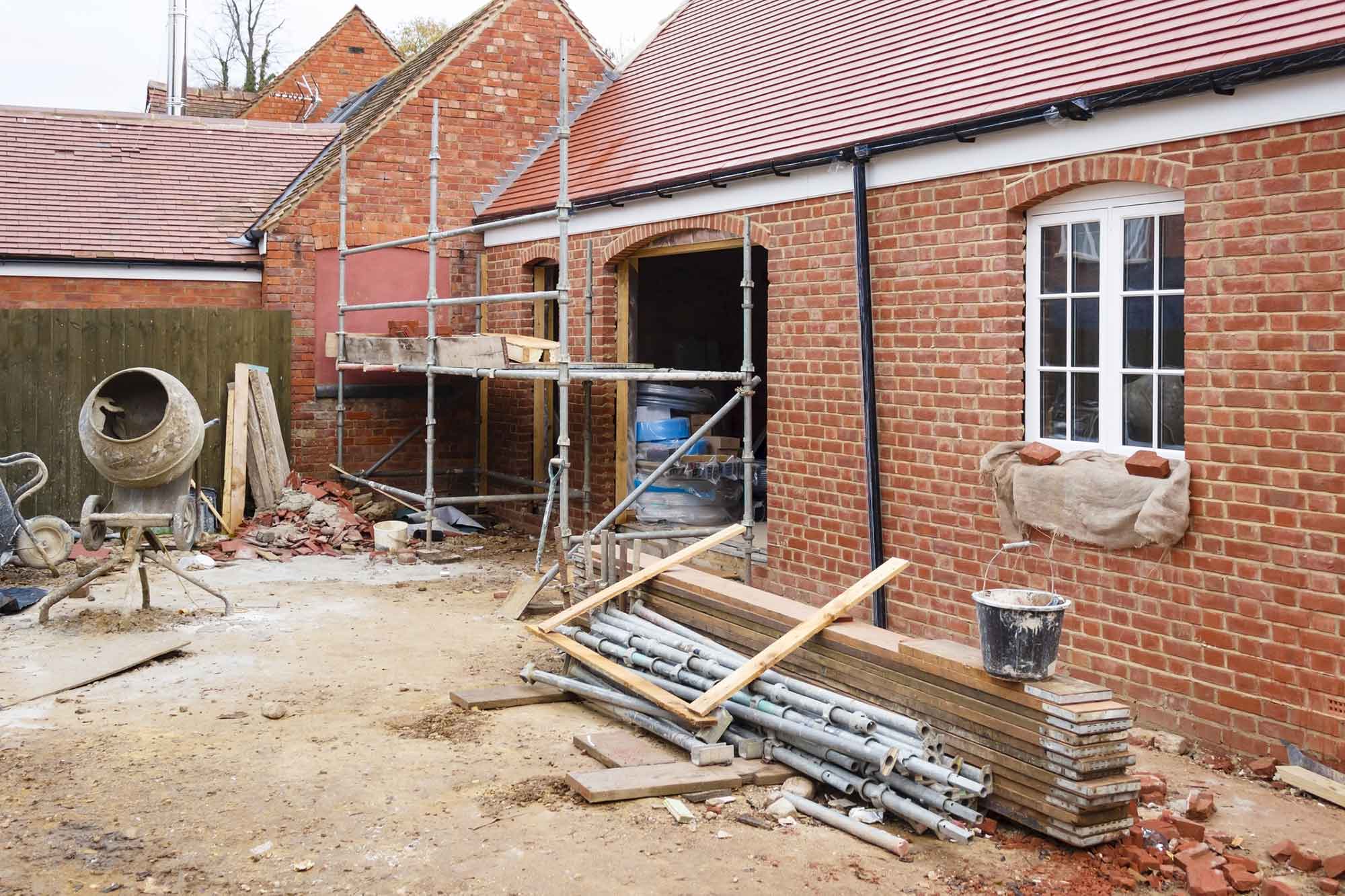 House renovations with scaffolding and cement mixer